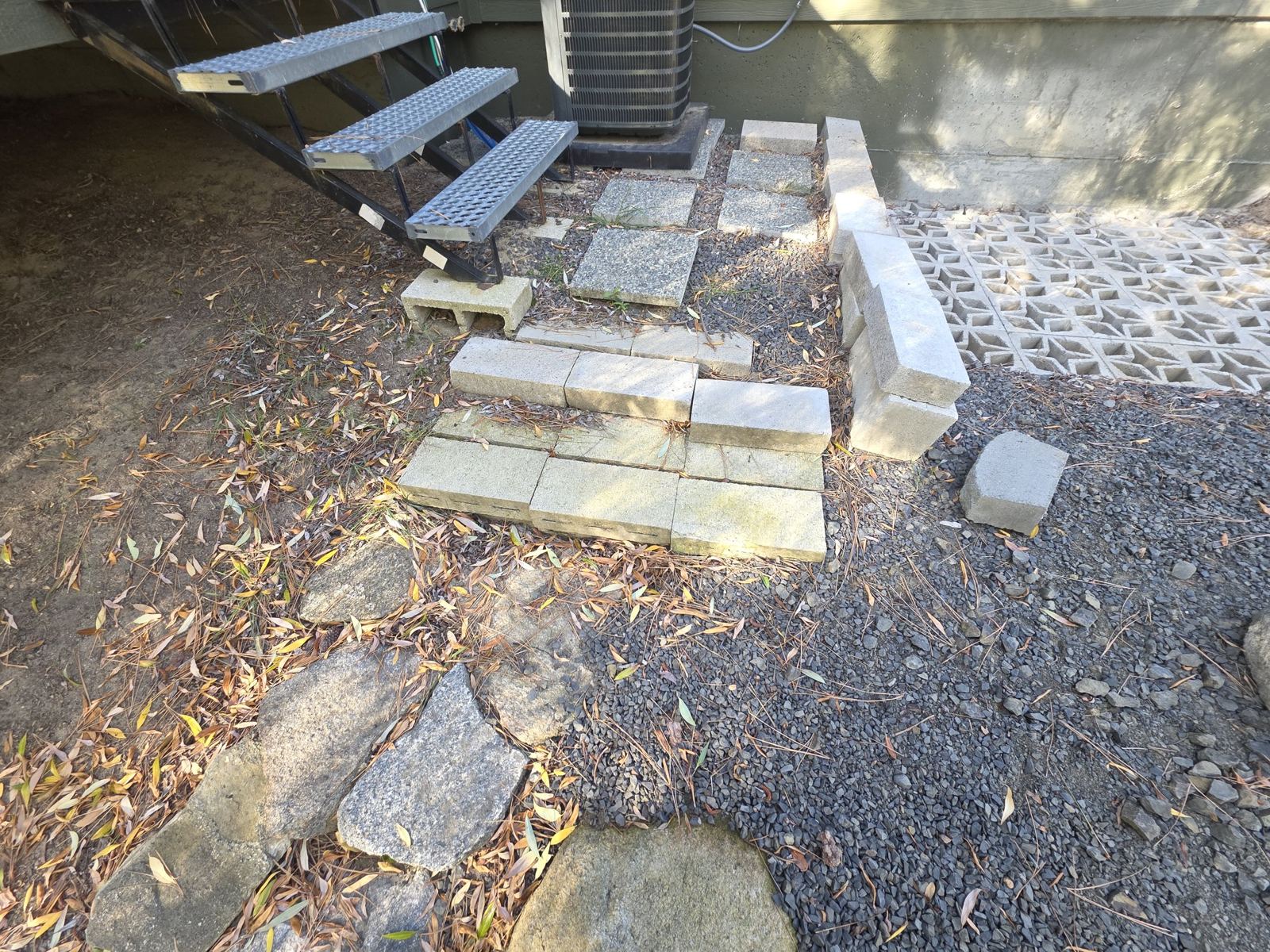 Patio area before: loose blocks, leaves and dirt